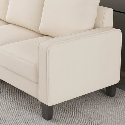 Canapé en tissu beige avec accoudoirs carrés et dossier capitonné