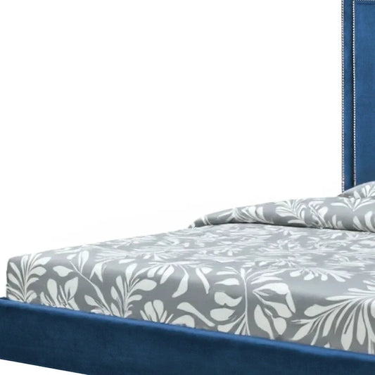 Lit king size en bois massif bleu marine, recouvert de velours et orné de clous décoratifs