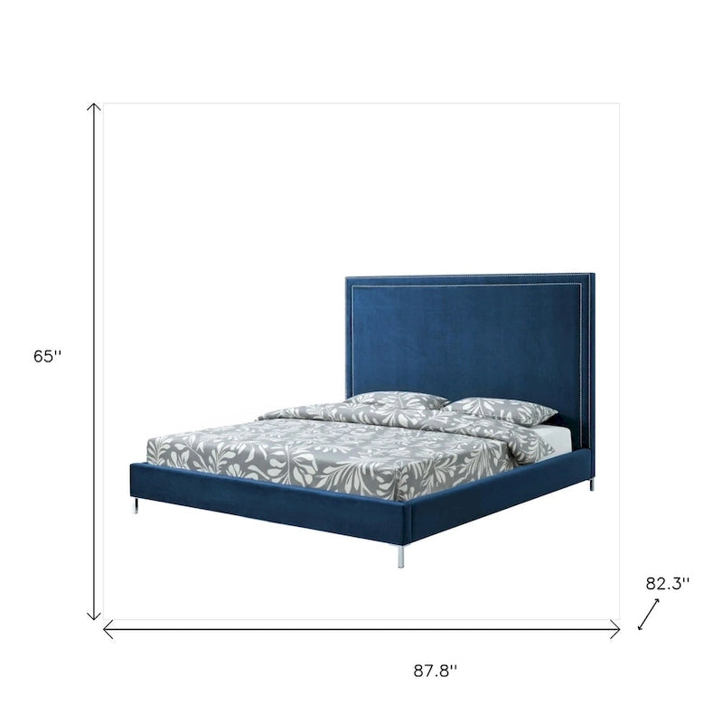 Lit king size en bois massif bleu marine, recouvert de velours et orné de clous décoratifs